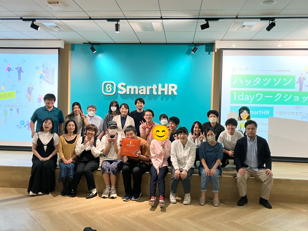 SmartHRのロゴをバックに参加者全員で撮った集合写真