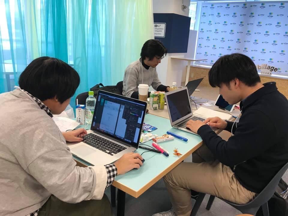 3人が特定のテーマに対してそれぞれが意見を出し合っている写真