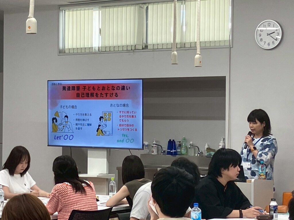 山崎さんがモニターを使いながら参加者の前で講義をしている